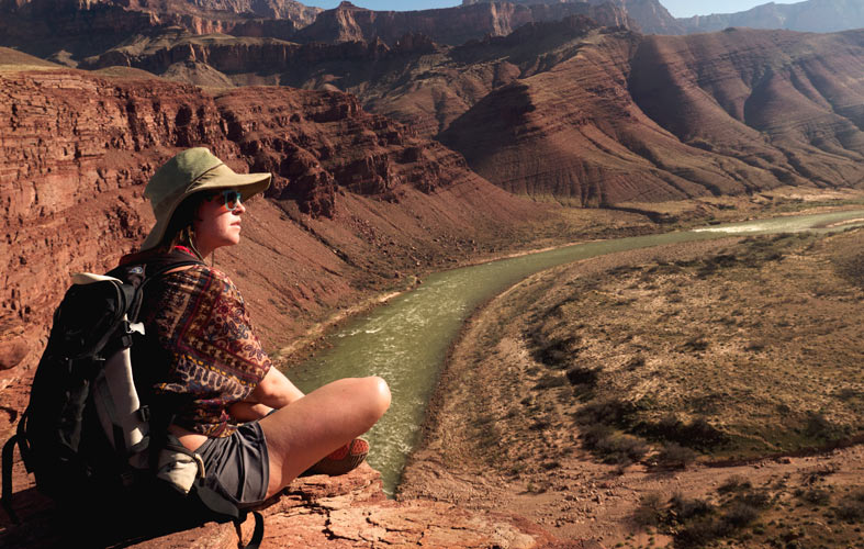 A woman looks out over the river from high on a ridge abover the Unkar Delta